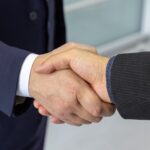Two professionals shaking hands in a business setting